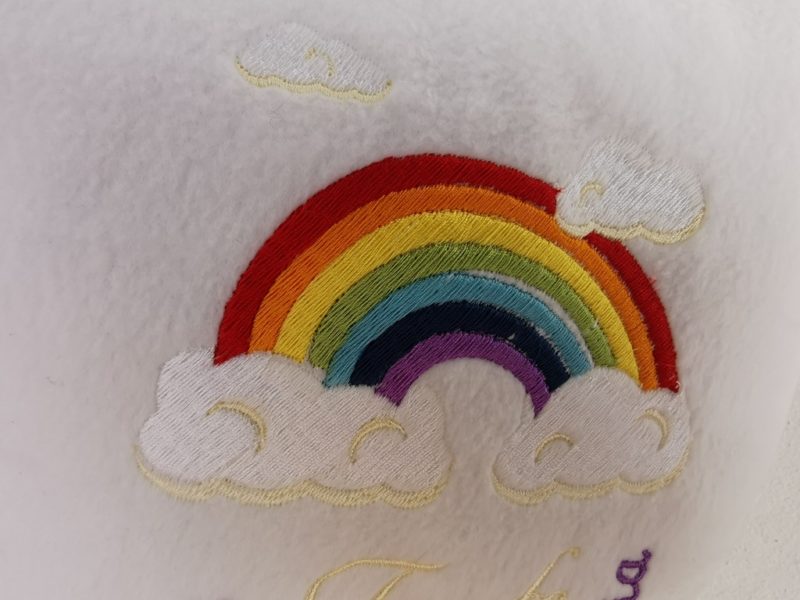 Taufkissen bestickt mit Name und Taufort, Taufdatum und Regenbogen