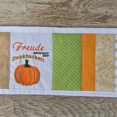 Tassenuntersetzer in Patchworkarbeit, bestickt mit Kürbis zur Herbstzeit. Mitbringsel und Geschenkidee zur herbstlichen Tischdekoration