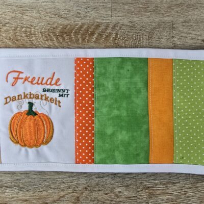 Tassenuntersetzer in Patchworkarbeit, bestickt mit Kürbis zur Herbstzeit. Mitbringsel und Geschenkidee zur herbstlichen Tischdekoration