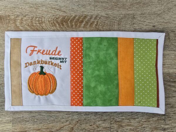 Tassenuntersetzer in Patchworkarbeit, bestickt mit Kürbis zur Herbstzeit. Mitbringsel und Geschenkidee zur herbstlichen Tischdekoration