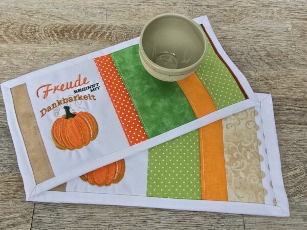 Tassenuntersetzer in Patchworkarbeit, bestickt mit Kürbis zur Herbstzeit. Mitbringsel und Geschenkidee zur herbstlichen Tischdekoration