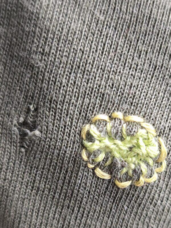 fertige Reparatur eine kleinen Lochs im T-Shirt mit Bestickung eines