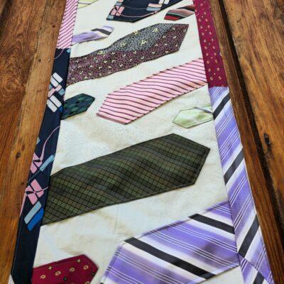 Tischläufer aus 9 Krawatten genäht, mit Rand. Rückseite Baumwolle