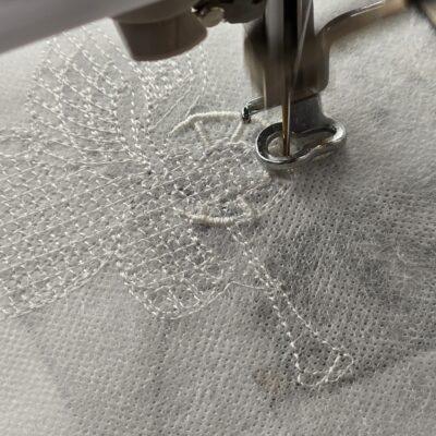 der Engel wird gestickt aus Spitze maschinengestickt in der Free standing lace Technik