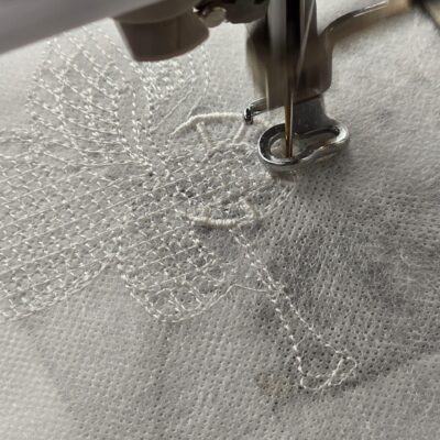 der Engel wird gestickt aus Spitze maschinengestickt in der Free standing lace Technik