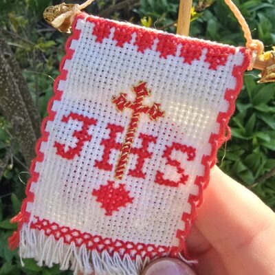 Handgesticktes Osterfähnchen mit IHS und Osterlamm. Doppelseitig bestickt, mit feinen Goldakzenten. Traditionelle, ruhige Handarbeit – ideal für Osterlammkuchen und Osterdeko.