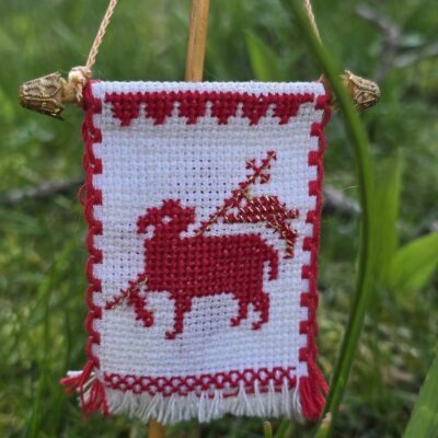 Handgesticktes Osterfähnchen mit IHS und Osterlamm. Doppelseitig bestickt, mit feinen Goldakzenten. Traditionelle, ruhige Handarbeit – ideal für Osterlammkuchen und Osterdeko.