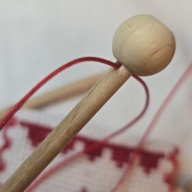 Herstellung des handgesticktes Osterfähnchen mit IHS und Osterlamm. Doppelseitig bestickt, mit feinen Goldakzenten. Traditionelle, ruhige Handarbeit – ideal für Osterlammkuchen und Osterdeko.