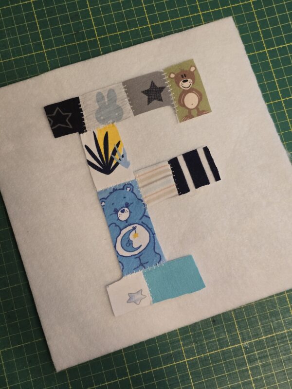 Ein Erinnerungsbild aus Reste und Abschnitte einer fertiggesteltlen Patchworkdecke aus Baby- und Kinderkleidung