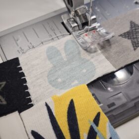 Ein Erinnerungsbild aus Reste und Abschnitte einer fertiggesteltlen Patchworkdecke aus Baby- und Kinderkleidung