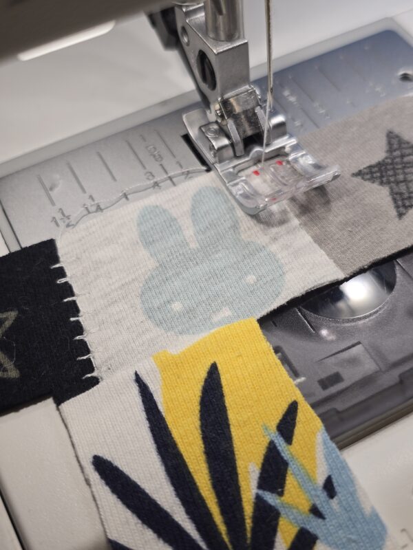 Ein Erinnerungsbild aus Reste und Abschnitte einer fertiggesteltlen Patchworkdecke aus Baby- und Kinderkleidung