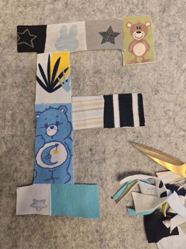 Ein Erinnerungsbild aus Reste und Abschnitte einer fertiggesteltlen Patchworkdecke aus Baby- und Kinderkleidung