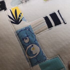 Ein Erinnerungsbild aus Reste und Abschnitte einer fertiggesteltlen Patchworkdecke aus Baby- und Kinderkleidung