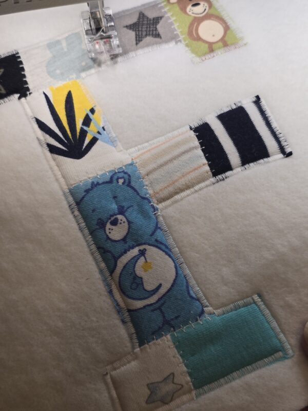 Ein Erinnerungsbild aus Reste und Abschnitte einer fertiggesteltlen Patchworkdecke aus Baby- und Kinderkleidung